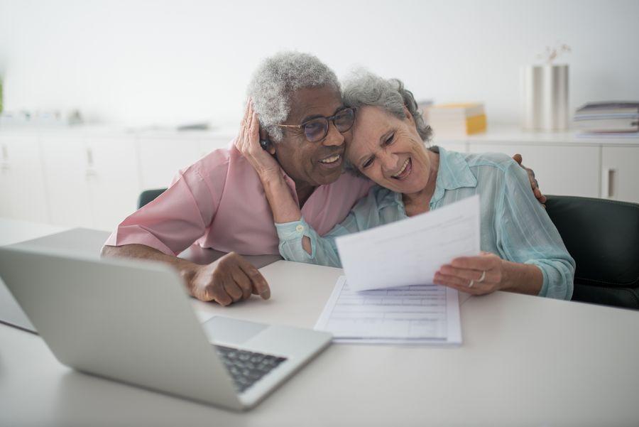 Senior couple smiling while reviewing retirement and protection documents